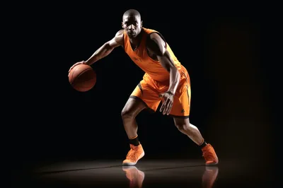 Professional Basketball Player Dribbling Ball In Studio