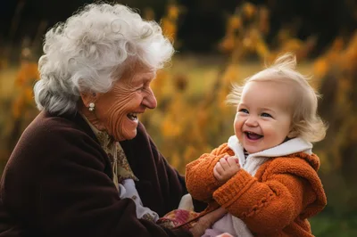 Elderly Woman Laughing With Her Toddler Grandchild Outdoors
