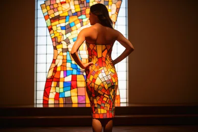 Woman Wearing Stained Glass Pattern Dress Standing Before Window