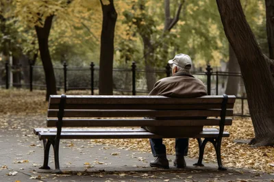 Elderly Man Sitting Alone On A Park Bench