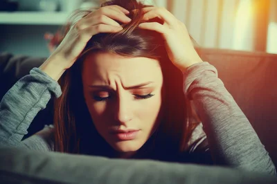 Stressed Young Woman Holding Her Head In Distress