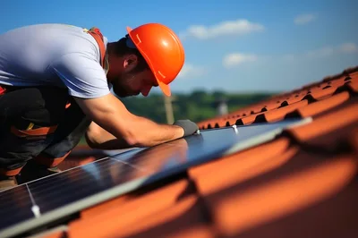Professional Roofer Installing Solar Panels on Tiled Roof