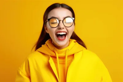 Young Woman Laughing With Eyes Closed Wearing Yellow Hoodie