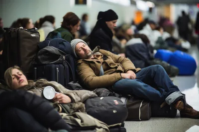 Exhausted Travelers Sleeping on Airport Terminal Floor