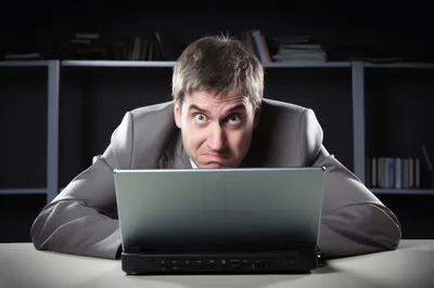 Stressed Businessman Looking At Laptop Screen In Office