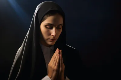 Young Nun Praying With Hands Clasped In Devotion