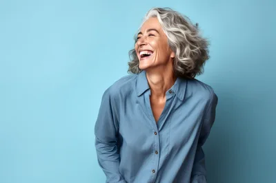 Happy Mature Woman Laughing Against Blue Background