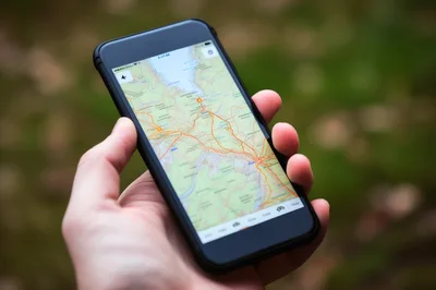 Person Holding Smartphone Displaying Digital Map Navigation