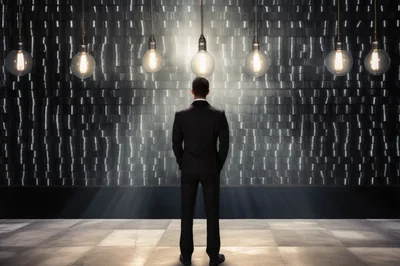 Businessman Standing Before A Wall Of Light Bulbs