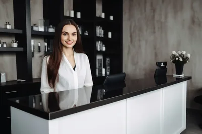 Professional Receptionist Standing Behind Modern Salon Desk