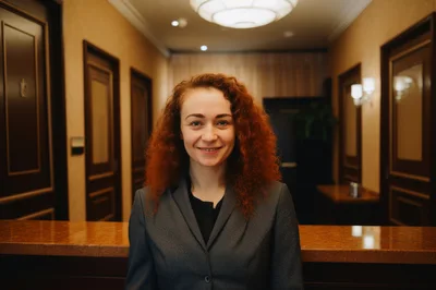 Professional Receptionist Standing Behind Hotel Front Desk