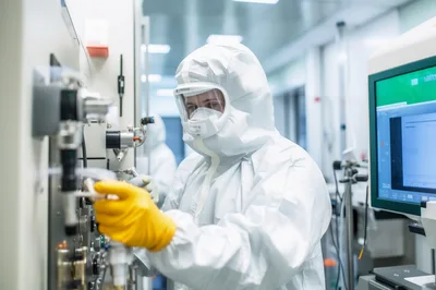 Scientist Operating Semiconductor Manufacturing Equipment In Cleanroom