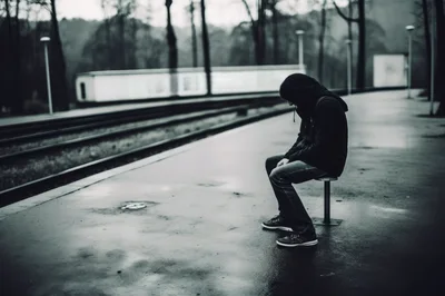 Lonely Person Sitting On A Train Platform Bench