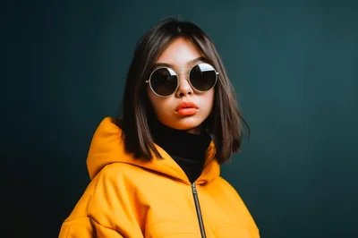 Young Woman Wearing Yellow Jacket And Round Sunglasses