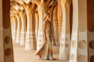 Elegant Woman Walking Through Gaudi Style Architectural Columns