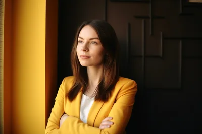 Professional Woman In Yellow Blazer Standing By Window