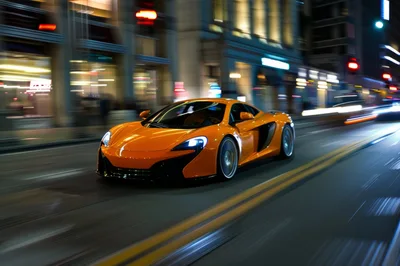 Orange McLaren Sports Car Driving Through City Streets