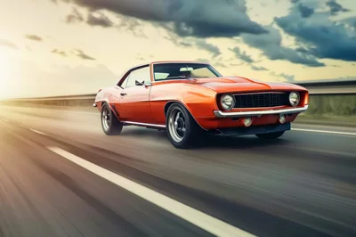 Classic Orange Muscle Car Driving On Highway