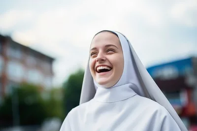 Young Nun Laughing Outdoors In Bright Daylight