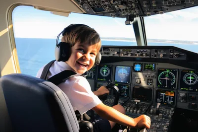Happy Young Boy Pretending To Pilot An Airplane