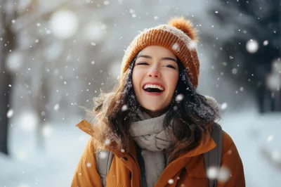 Happy Young Woman Laughing During Winter Snowfall