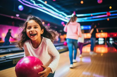 Happy Young Girl Holding Bowling Ball at Alley