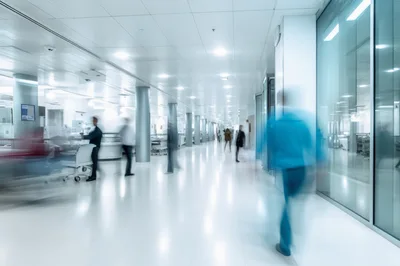 Blurred Medical Staff Walking Through Modern Hospital Corridor