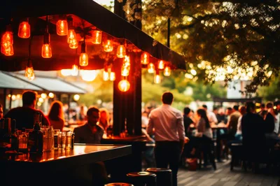 Outdoor Bar Scene With Warm String Lighting At Sunset