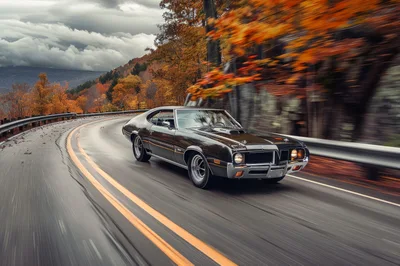 Classic Muscle Car Driving On A Winding Autumn Road