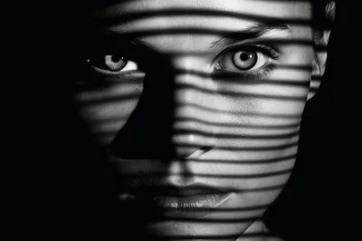 Close Up Portrait Of Woman With Blinds Shadow