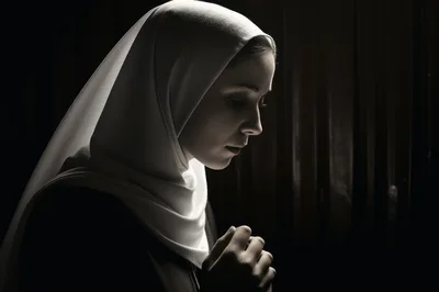 Young Woman In A Hijab Praying In Low Light