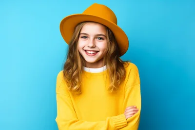 Smiling Young Girl Wearing Yellow Hat and Sweater