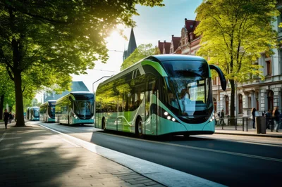 Modern Electric Buses Driving Along A Sunny City Street