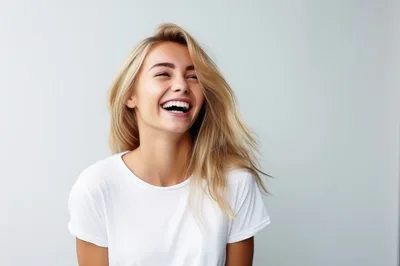 Happy Young Woman Laughing Against A Plain Background