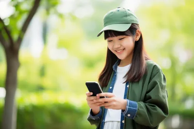 Young Asian Girl Using Smartphone Outdoors