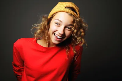 Happy Young Woman Wearing A Yellow Beanie And Red Shirt