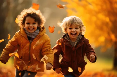 Two Happy Children Running Through Autumn Leaves