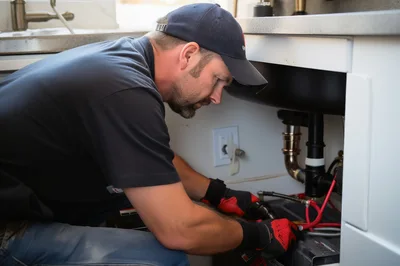 Professional Plumber Repairing Kitchen Sink Plumbing