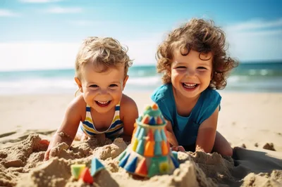 Two Happy Toddlers Playing With Sandcastle On Beach