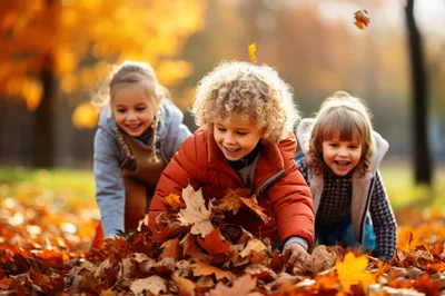 Three Happy Children Playing In Autumn Leaves