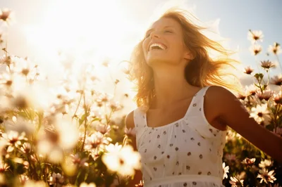 Happy Woman Laughing In A Sunny Flower Field