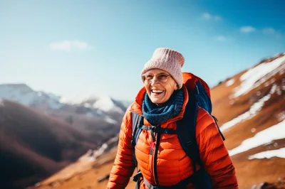 Senior Woman Hiking In Snowy Mountain Landscape