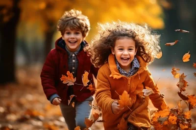 Happy Children Running Through Autumn Leaves