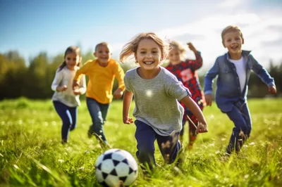 Group of Happy Children Playing Soccer Outdoors