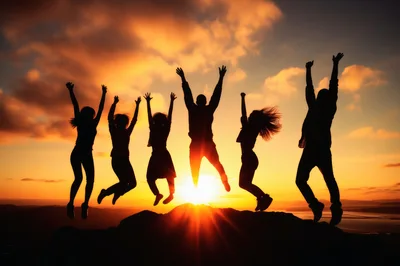 Group Of Friends Jumping In Silhouette At Sunset