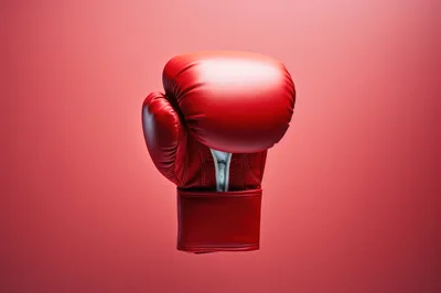 Single Red Boxing Glove Floating Against Red Background