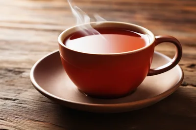 Steaming Cup Of Hot Tea On Wooden Table