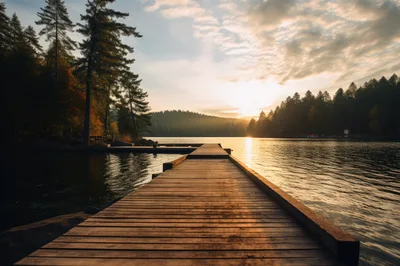 Wooden Pier Extending Into A Calm Mountain Lake At Sunset