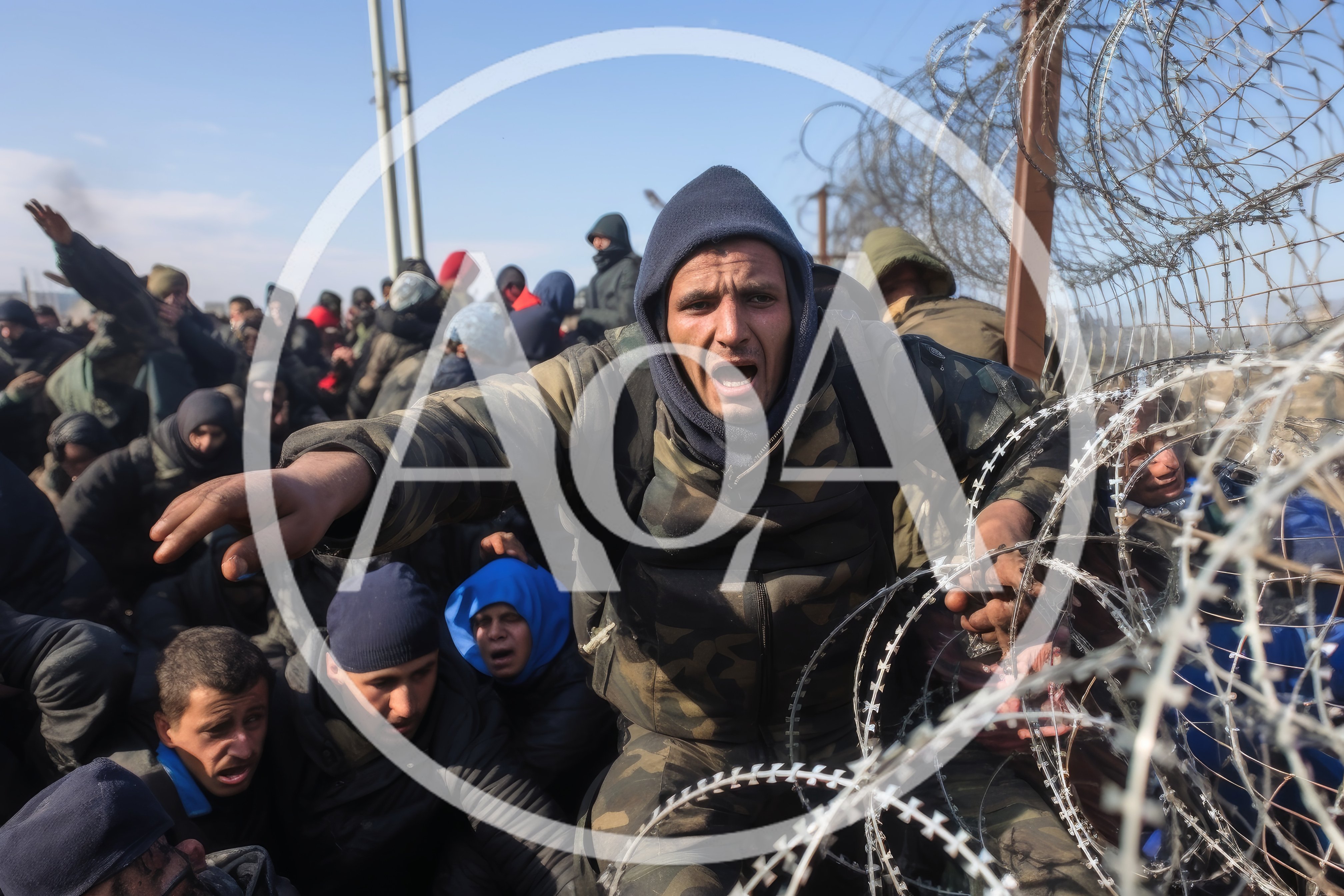 Migrants Pushing Against Barbed Wire Border Fence
