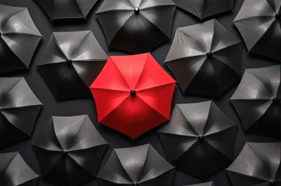 Red Umbrella Surrounded By Black Umbrellas